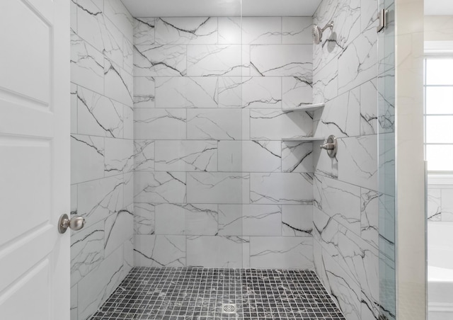 bathroom featuring a marble finish shower and healthy amount of natural light
