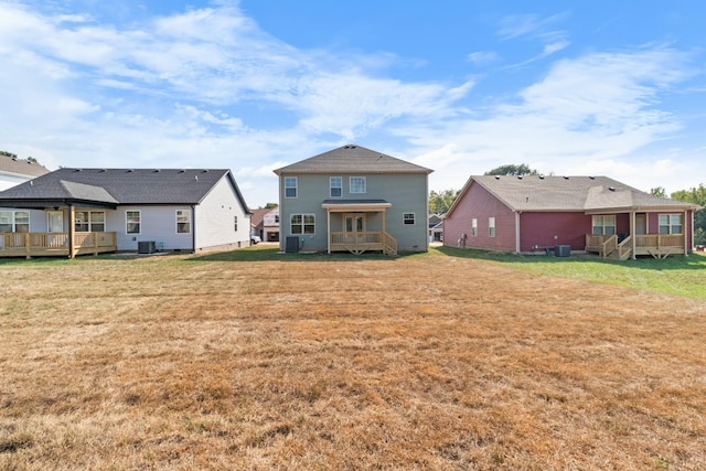 rear view of property featuring a wooden deck, a lawn, and central AC unit