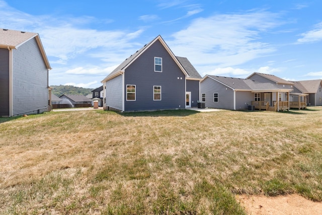 back of property with cooling unit and a yard