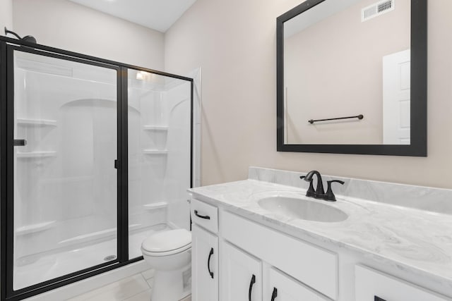 full bath featuring a stall shower, toilet, vanity, and tile patterned floors