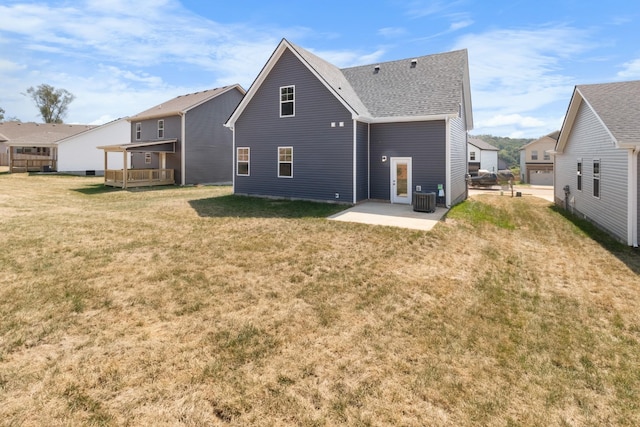 back of property featuring central AC unit, a patio area, a yard, and a shingled roof
