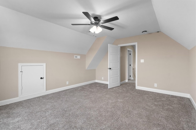 bonus room with vaulted ceiling, carpet flooring, a ceiling fan, and baseboards