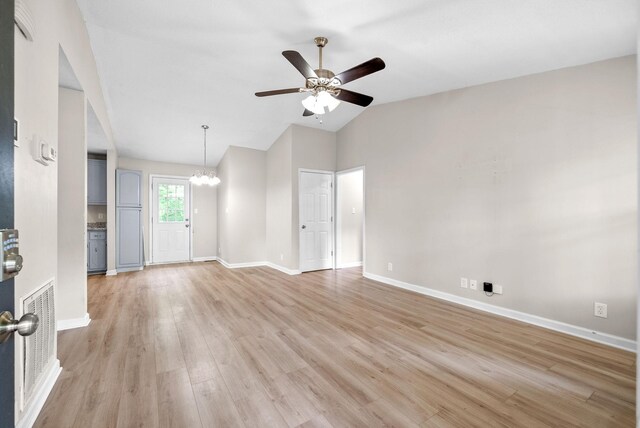 938 Merritt Lewis Ln, Clarksville, TN 37042 - unfurnished room with a chandelier, vaulted ceiling, a ceiling fan, light wood-style floors, and baseboards