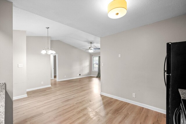 938 Merritt Lewis Ln, Clarksville, TN 37042 - unfurnished living room featuring a ceiling fan, a chandelier, light wood-style floors, baseboards, and vaulted ceiling