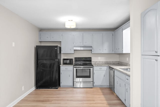 938 Merritt Lewis Ln, Clarksville, TN 37042 - kitchen featuring black appliances, under cabinet range hood, light wood-style flooring, and baseboards