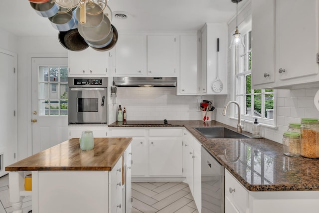 1033 Percy Warner Blvd, Nashville, TN 37205 - kitchen featuring appliances with stainless steel finishes, a sink, under cabinet range hood, wooden counters, and plenty of natural light