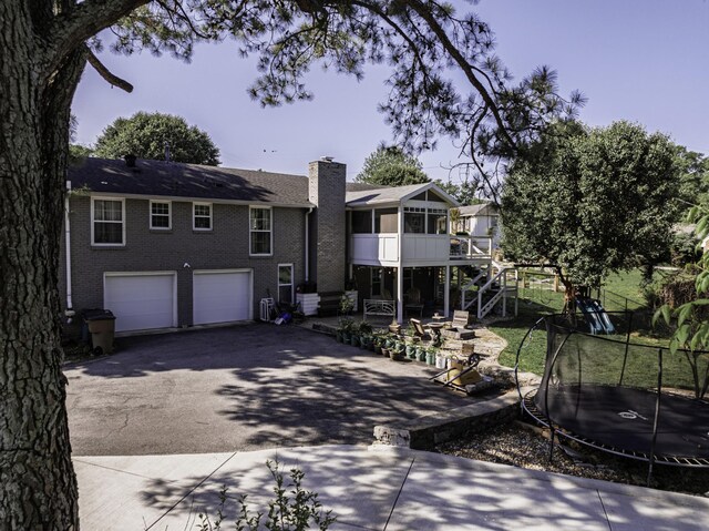 1033 Percy Warner Blvd, Nashville, TN 37205 - view of front of home with a trampoline, driveway, a chimney, stairs, and brick siding