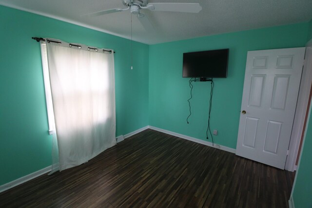 unfurnished bedroom featuring dark wood-type flooring, baseboards, and ceiling fan