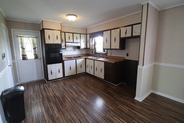 kitchen with oven, gas cooktop, under cabinet range hood, ornamental molding, and dark wood-type flooring