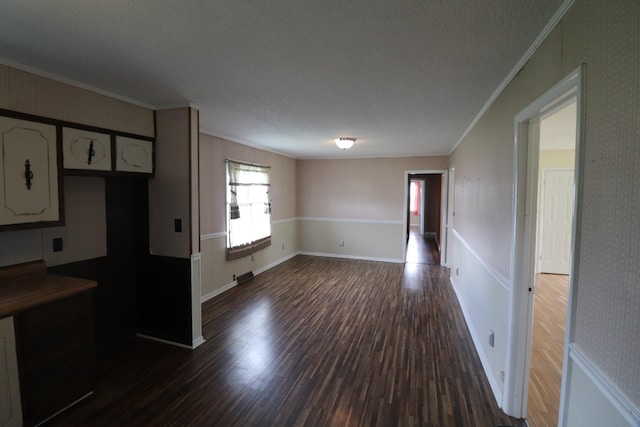 kitchen featuring ornamental molding, dark wood-type flooring, white cabinetry, a textured ceiling, and baseboards