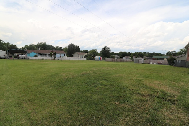 view of yard featuring a carport, a storage unit, and an outdoor structure