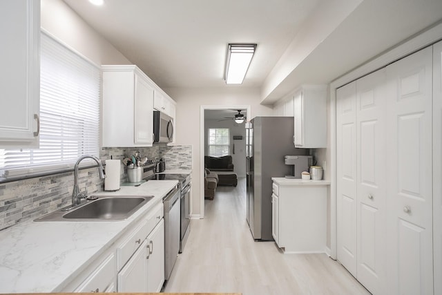 1543 James Gafford Dr, La Vergne, TN 37086 - kitchen featuring stainless steel appliances, a sink, backsplash, white cabinets, and ceiling fan
