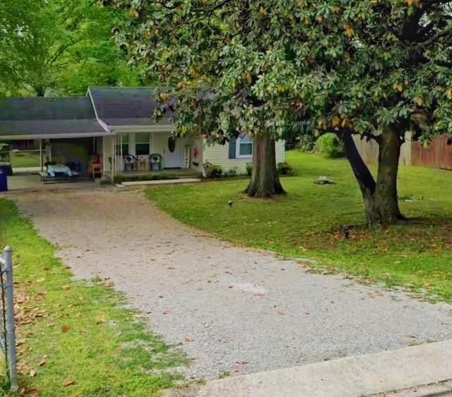 view of front of house featuring gravel driveway, covered porch, and a carport