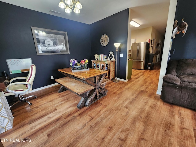 office space featuring wood finished floors, baseboards, and a chandelier