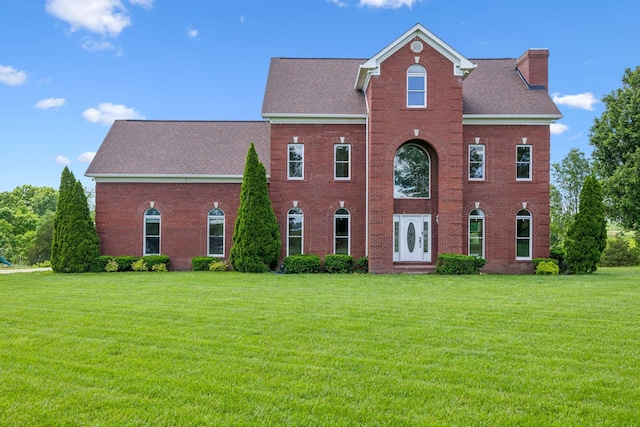 122 Windcrest Dr, Hohenwald, TN 38462 - view of front of house with brick siding, a front lawn, a chimney, and a shingled roof
