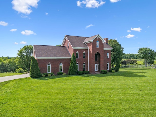 122 Windcrest Dr, Hohenwald, TN 38462 - view of front of home featuring a front yard, a chimney, and brick siding