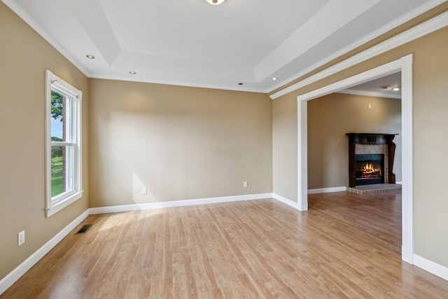 122 Windcrest Dr, Hohenwald, TN 38462 - empty room with ornamental molding, a raised ceiling, healthy amount of natural light, light wood finished floors, and a fireplace