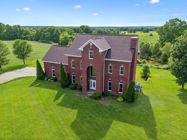 122 Windcrest Dr, Hohenwald, TN 38462 - view of front of property with a front yard, concrete driveway, a chimney, and brick siding