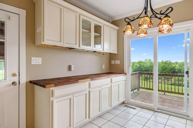 122 Windcrest Dr, Hohenwald, TN 38462 - kitchen with wood counters, light tile patterned floors, ornamental molding, healthy amount of natural light, and glass insert cabinets