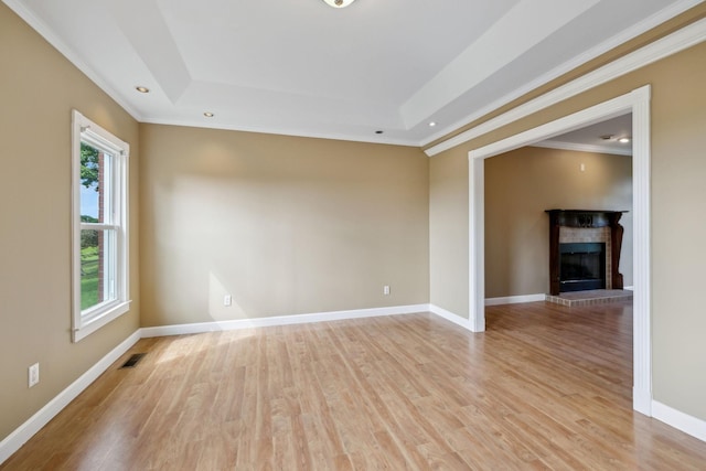 122 Windcrest Dr, Hohenwald, TN 38462 - spare room with crown molding, a raised ceiling, light wood-style flooring, a fireplace, and baseboards