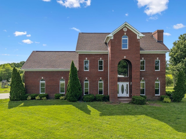 122 Windcrest Dr, Hohenwald, TN 38462 - view of front of home featuring a chimney, a front lawn, brick siding, and a shingled roof
