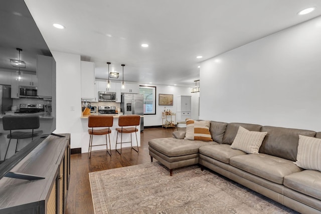 living room with dark wood-style flooring and recessed lighting