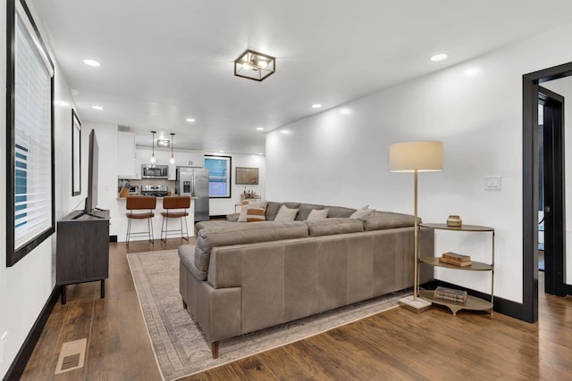 living area featuring dark wood-style floors, baseboards, and recessed lighting