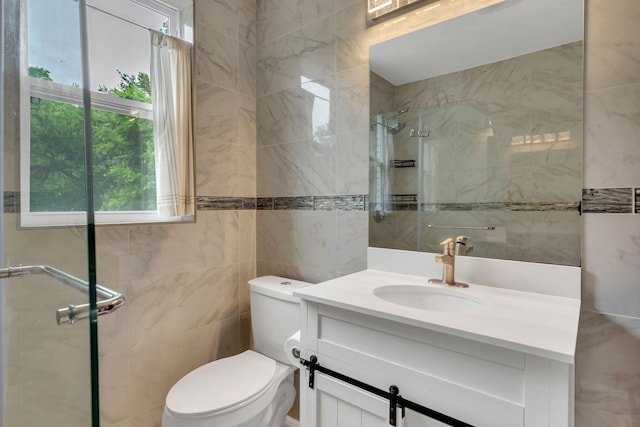 full bath with tile walls, tiled shower, toilet, and vanity