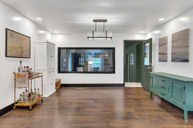living area with dark wood-type flooring and recessed lighting