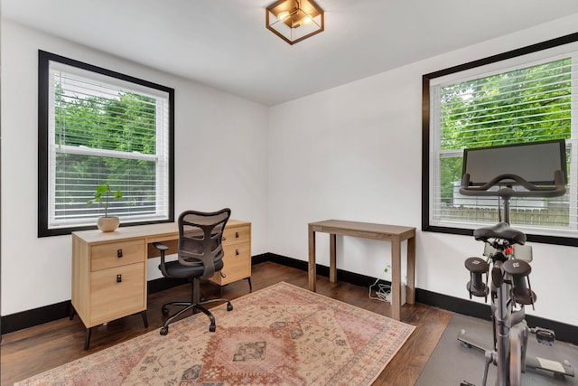 office with dark wood-style flooring and baseboards