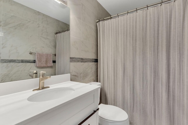 full bathroom featuring tile walls, toilet, and vanity