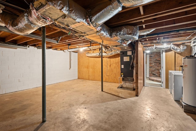 unfinished basement with water heater, heating unit, and washer / dryer