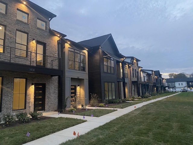 view of property exterior with a residential view, a yard, and a balcony