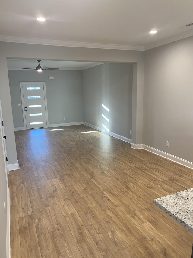 unfurnished room featuring crown molding, hardwood / wood-style floors, baseboards, a ceiling fan, and recessed lighting