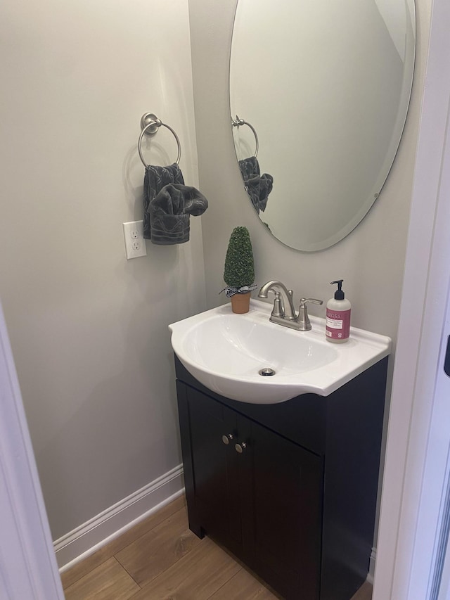 bathroom featuring vanity, wood finished floors, and baseboards