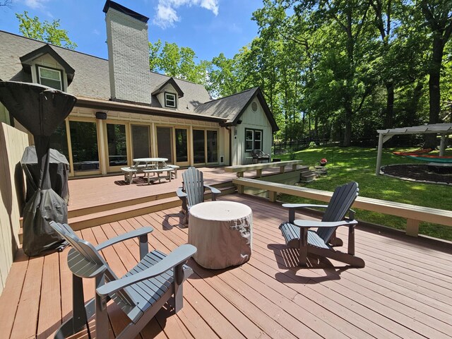wooden deck with outdoor dining area and a lawn