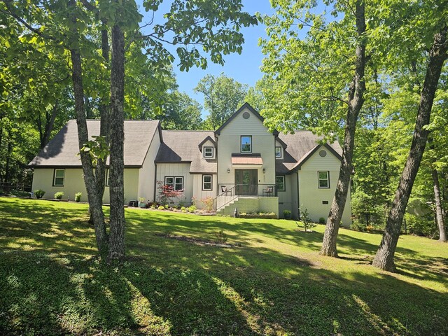 rear view of property featuring a lawn and board and batten siding