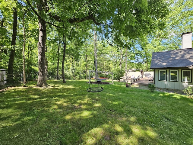 view of grassy yard with a deck