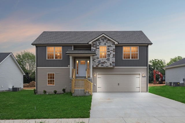1543 Fredrick Dr, Clarksville, TN 37042 - view of front facade with driveway, a garage, a lawn, a shingled roof, and stone siding