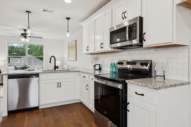 1543 Fredrick Dr, Clarksville, TN 37042 - kitchen with stainless steel appliances, a peninsula, dark wood finished floors, a ceiling fan, and backsplash