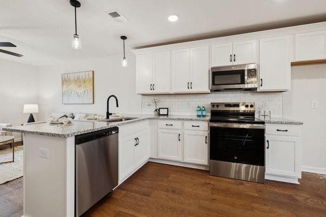 1543 Fredrick Dr, Clarksville, TN 37042 - kitchen featuring stainless steel appliances, a peninsula, decorative backsplash, white cabinets, and recessed lighting