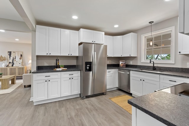 400 Log Wall Rd, Dickson, TN 37055 - kitchen featuring stainless steel appliances, a sink, light wood-style flooring, dark countertops, and white cabinetry