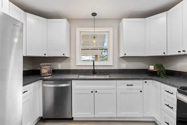 400 Log Wall Rd, Dickson, TN 37055 - kitchen with appliances with stainless steel finishes, a sink, white cabinets, hanging light fixtures, and dark stone countertops