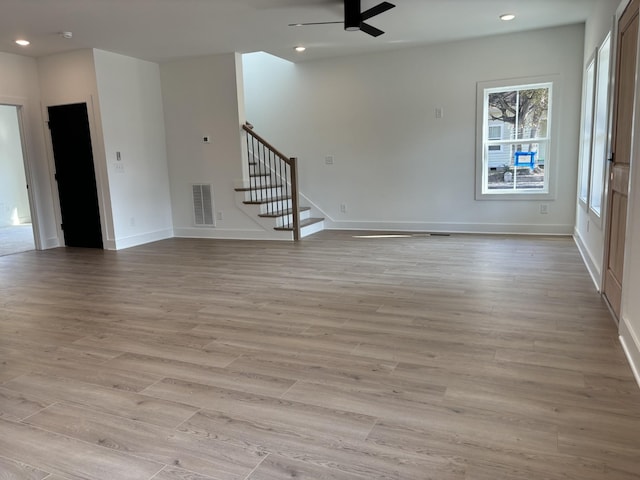 unfurnished living room featuring stairway, ceiling fan, baseboards, light wood-style floors, and recessed lighting