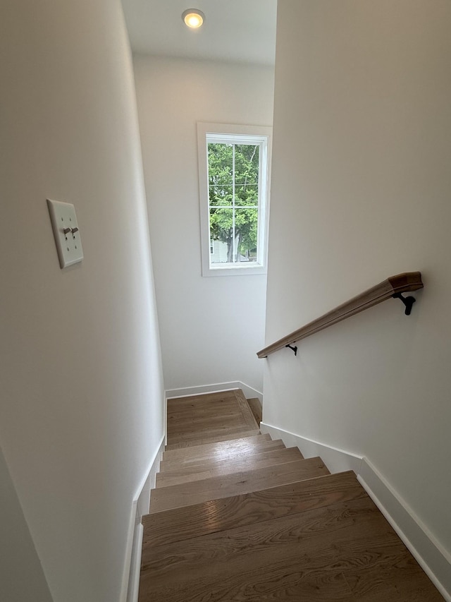 stairway with wood finished floors and baseboards