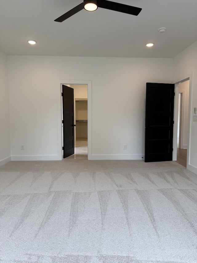 spare room featuring ceiling fan, baseboards, a smoke detector, light carpet, and recessed lighting