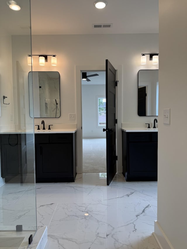 full bath featuring two vanities, marble tiled floors, baseboards, and recessed lighting