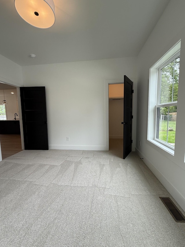unfurnished bedroom with light colored carpet and baseboards