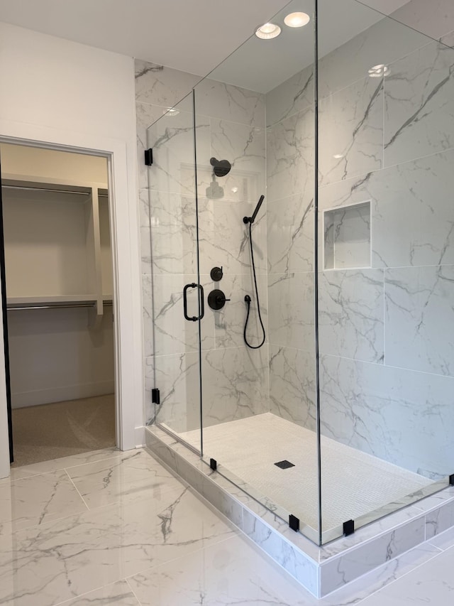 full bathroom with a marble finish shower, marble finish floors, a walk in closet, and recessed lighting