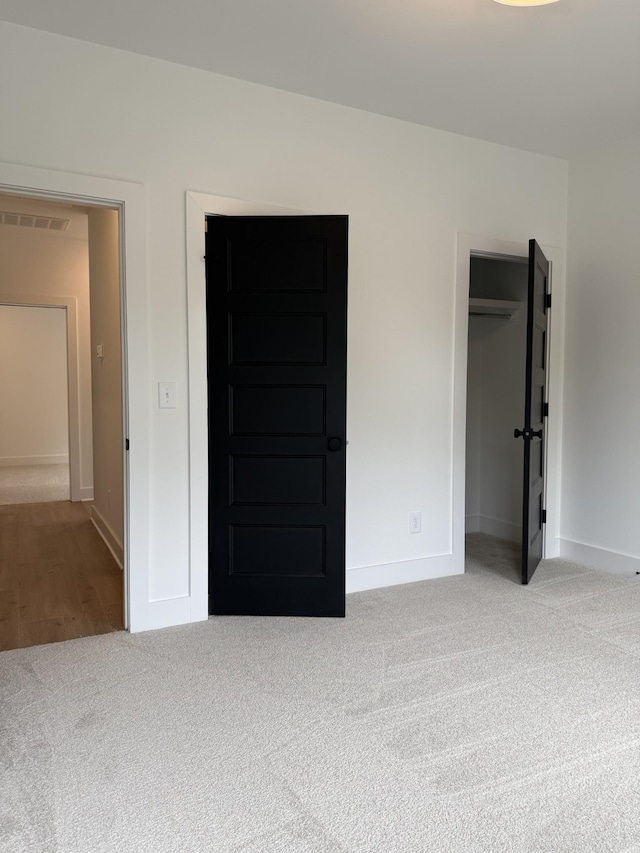 unfurnished bedroom featuring carpet, baseboards, and a closet